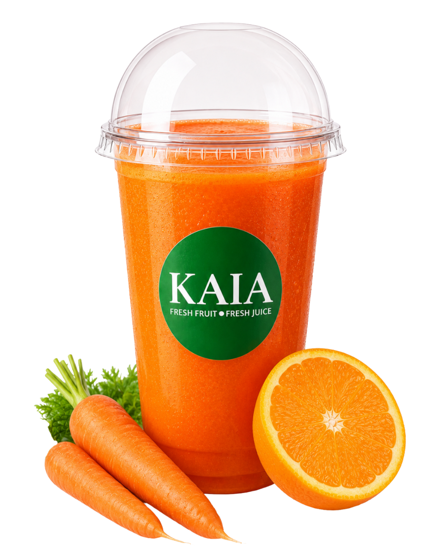 Deep Orange & Carrot juice in a clear plastic cup with a KAIA label, surrounded by carrots and an orange.