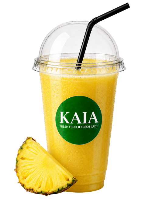 Yellow pineapple juice in a clear cup with a black straw and pineapple slice, featuring the KAIA brand.