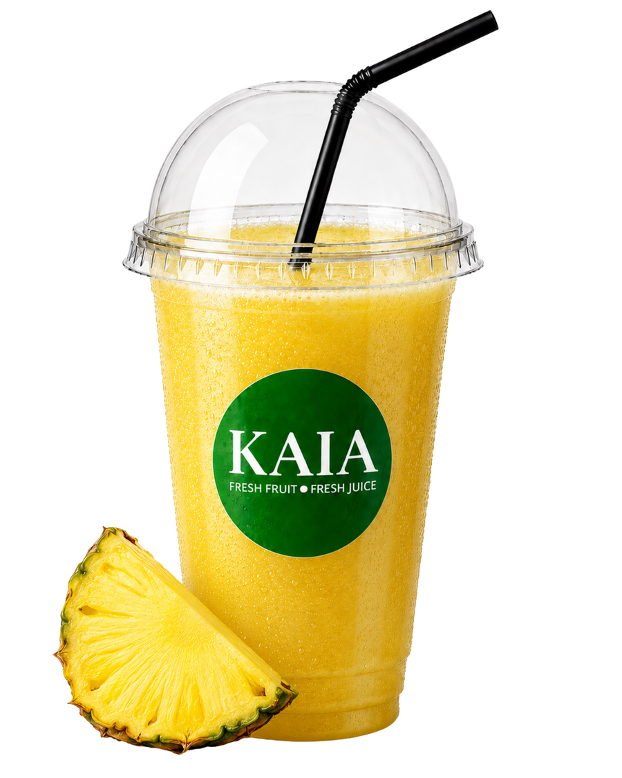 Yellow pineapple juice in a clear cup with a black straw and pineapple slice, featuring the KAIA brand.